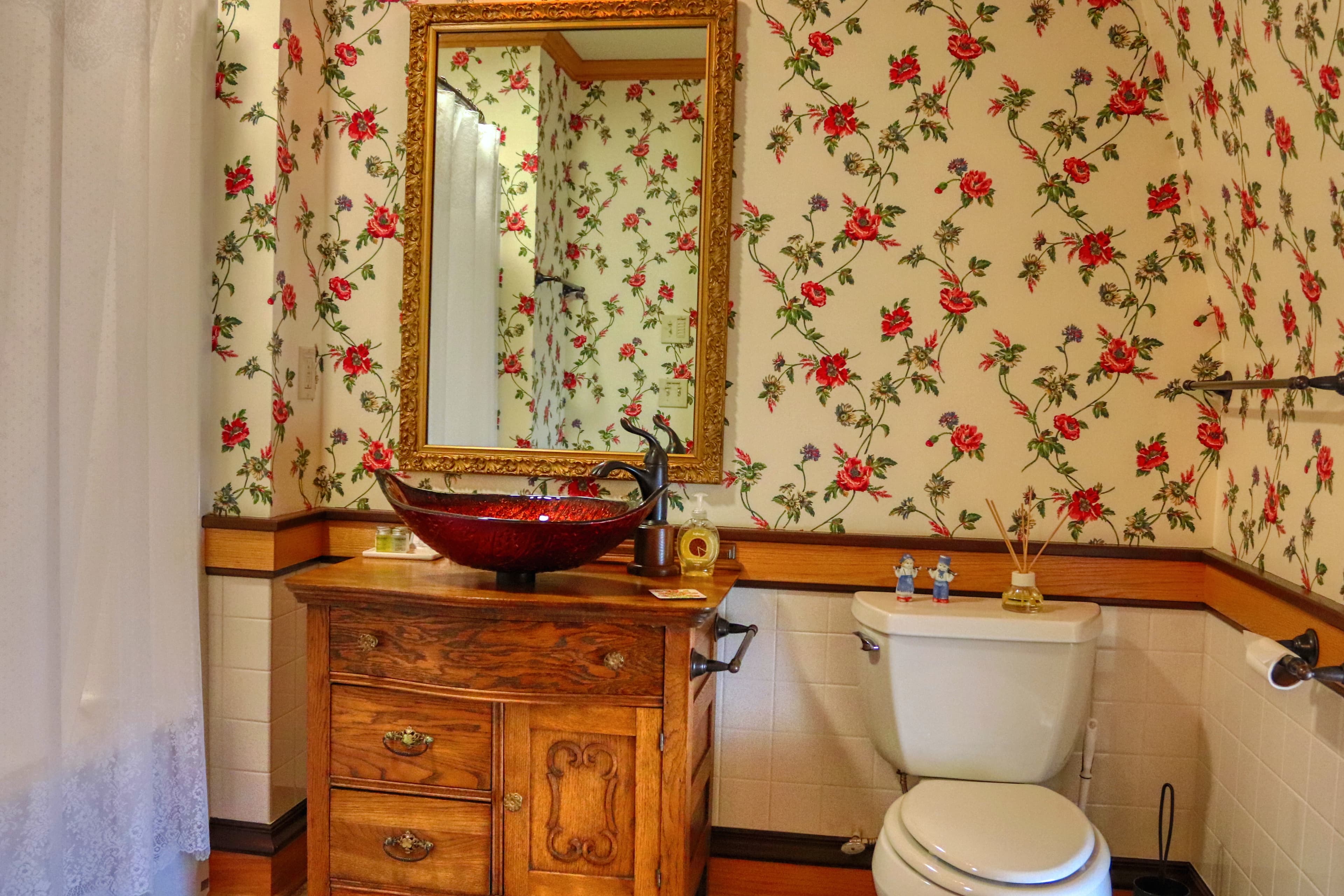 The ensuite bathroom features a Pella circle window, vintage glass sink encased in a antique dresser and offers you a modern tub/shower combination with a curated collection of spa-inspired amenities and high-end bath products. .