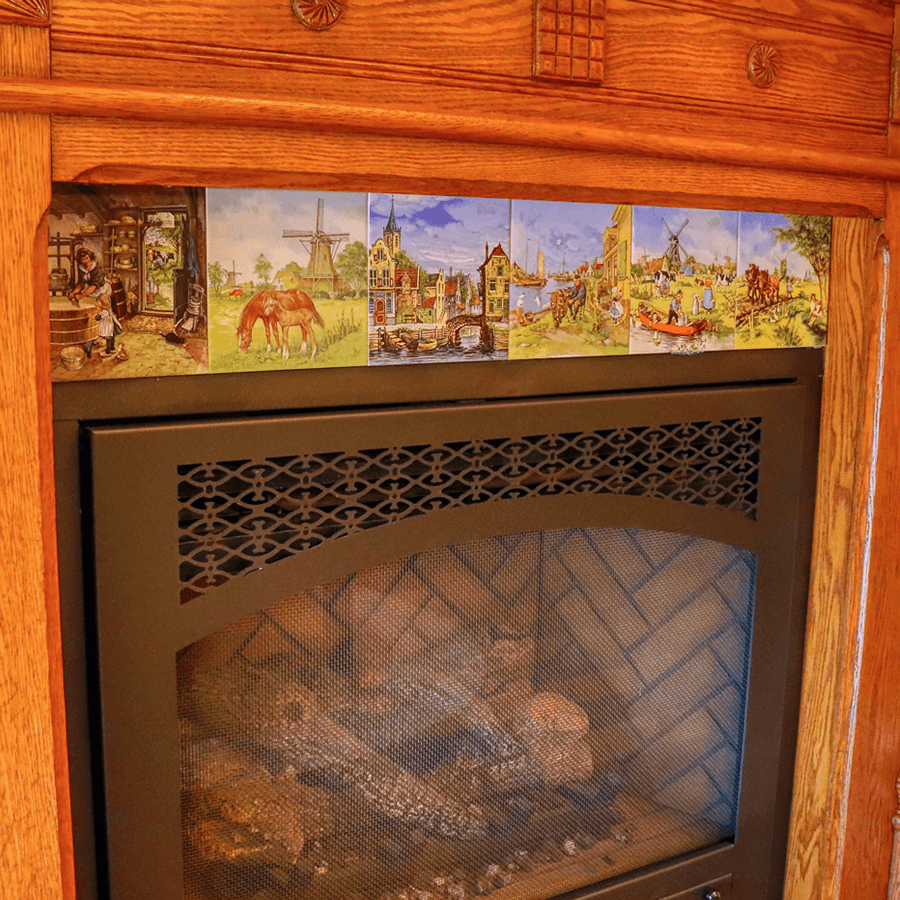 A fireplace decorated with a row of colorful vintage-style postcards depicting rural scenes and landscapes.